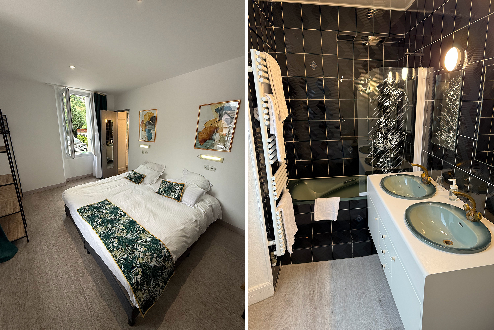 Twin-bed hotel room with white bedding, botanical pillows and wall art, next to a large window; adjacent bathroom visible beyond.