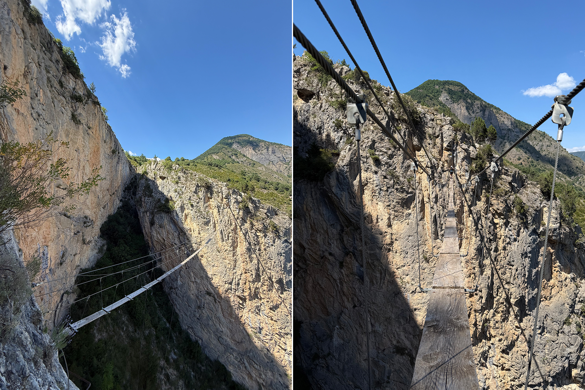 Suspension bridge with metal cables across a rocky gorge, mountains in distance under a clear blue sky.